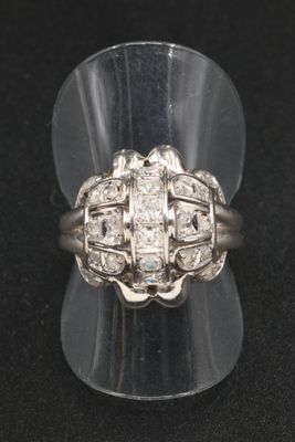 un gros plan d'une bague en diamant posée sur un présentoir transparent