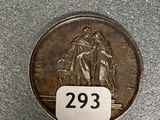a silver coin with a picture of two people on it