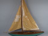 a model of a sailboat on display against a gray wall