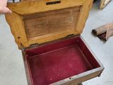 a person holding a wooden box with a red velvet inside