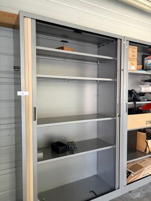 une armoire métallique avec des étagères, au milieu d'un garage
