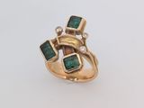 Gros plan sur une bague en or ornée d'émeraudes et de diamants