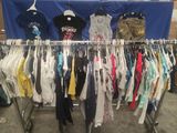 a lot of clothes hanging on a rack in a room