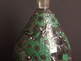 a glass vase with green flowers on it on a wooden table