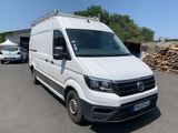the white van is parked in the parking lot next to a pile of wood