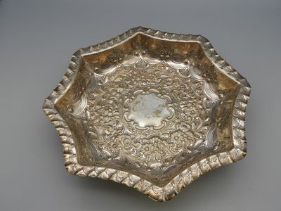 a silver plate with a design on it on a table