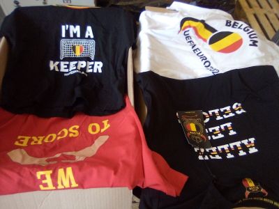 trois t-shirts qui se trouvent dans une boîte posée par terre