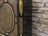 a black and gold chest sitting against a stone wall