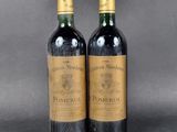 two bottles of wine sitting next to each other on a table