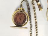 a gold pocket watch with a chain attached to it