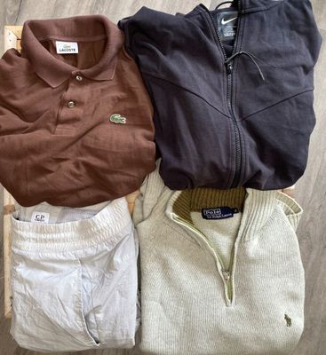 three men ' s sweaters sitting on top of a wooden crate