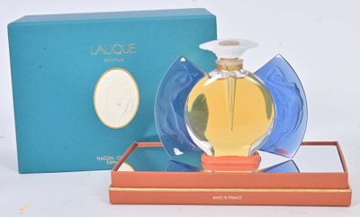 une image représentant un flacon de parfum posé sur une boîte bleue