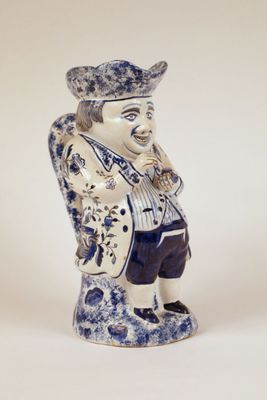 a blue and white figurine of a man with a hat on his head