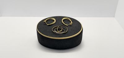 une image représentant une boîte noire sur laquelle sont posées une paire de boucles d'oreilles