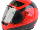 Le casque est rouge et noir et est muni d'un étau.