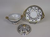 three porcelain dishes and a saucer on a white table