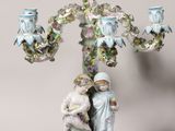 a figurine of a man and a woman holding a baby