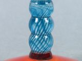 a glass vase with a yellow flower on top of it