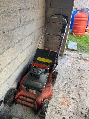 a lawn mower that is sitting on the side of the building