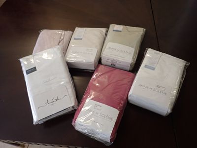 de nombreuses feuilles blanches et roses pliées sur une table