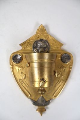une assiette en or ornée d'une horloge, posée sur un fond blanc