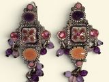deux paires de boucles d'oreilles ornées de pierres violettes et orange sur un fond blanc