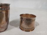 deux tasses en argent posées l'une à côté de l'autre sur une table