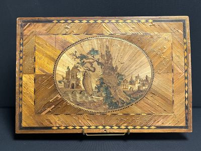 an old wooden box with a painting on it on a black surface
