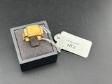 une bague en or dans une boîte noire sur laquelle est apposée une étiquette de prix