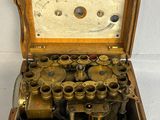 a wooden box with a bunch of old binoculars inside of it