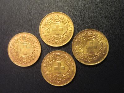 quatre pièces d'or posées sur une surface noire