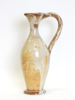 a brown and white vase sitting on a white surface
