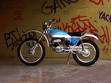 a motorcycle parked in front of a wall with graffiti on it