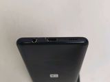 the back of a black cell phone sitting on top of a white surface