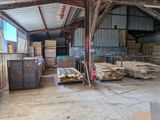de nombreuses piles de bois dans un entrepôt au toit métallique