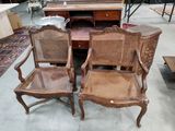 plusieurs chaises et une table dans une pièce avec beaucoup de meubles