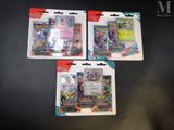 three packs of pokemon trading cards on a table