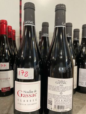 plusieurs bouteilles de vin rouge sont alignées sur un comptoir