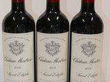 three bottles of red wine are lined up on a white surface