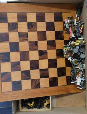 a wooden chess board in a box with a lot of pieces