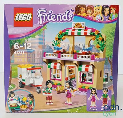 La boîte est ouverte pour montrer le contenu de la maison Lego Friends.