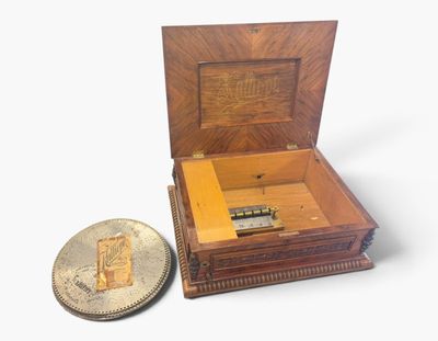 une petite boîte en bois contenant une pièce de monnaie