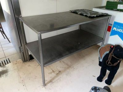 un homme debout dans une cuisine, avec une balance posée par terre