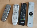 quatre télécommandes sont alignées sur une surface marron