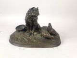 statue en bronze représentant un chien et deux canards sur un rocher