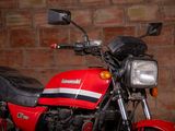 a red and black motorcycle parked in front of a brick wall
