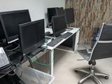 trois ordinateurs posés sur le bureau dans la pièce