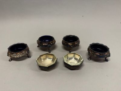 quatre bols argentés et bleus munis d'anses, posés sur un fond blanc
