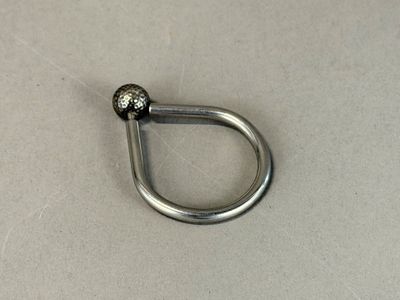 a metal hook with a ball on it on a table