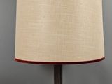 un gros plan d'une lampe posée sur une table, dont le cordon est branché